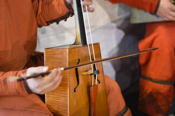 a musician plays an old oriental cello