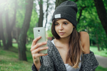 Młoda kobieta robi sobie selfie w parku.