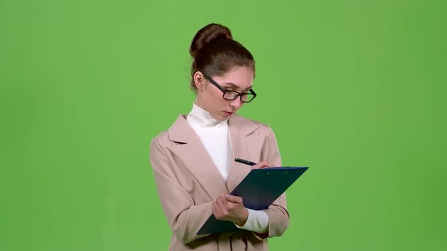 Manager fills the questionnaire with a pen on a paper tablet. Green screen