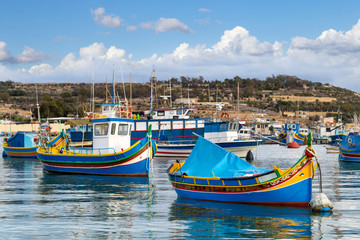 Naklejka na ściany i meble Traditional colourful painted Maltese fishing boats, called luzzu, in the small fishing village Marsaxlokk on Malta.