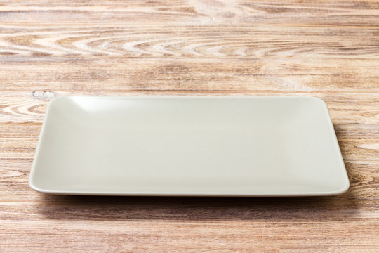 Blank rectangular plate on wooden background. top view