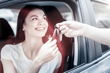 Successful and independent. Extremely happy young lady grinning broadly while sitting in her...