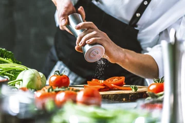 Foto op Plexiglas Chef-kok in de keuken met verse groenten (tomaten) © karepa
