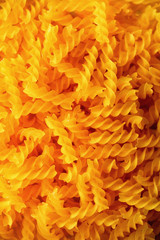 Fusilli noodles background, macaroni texture. Uncooked gluten free pasta from blend of corn and rice flour. Top view