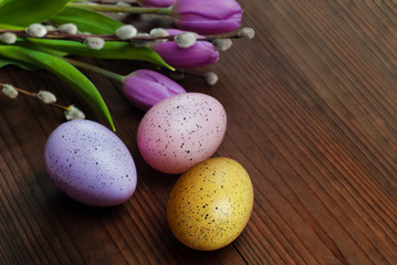 Obraz na płótnie Canvas Colored eggs on wooden background. Easter, Spring holidays