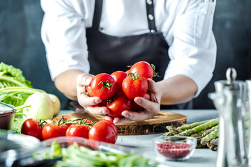 Chefkoch in der Küche mit Frischem Gemüse(Tomaten) - obrazy, fototapety, plakaty