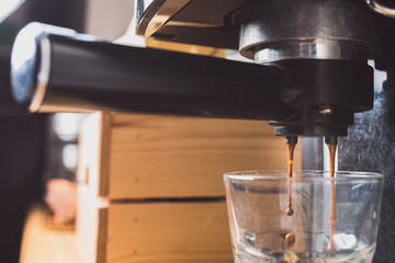 Espresso coffee preparation using coffee machine at home, shallow depth of field