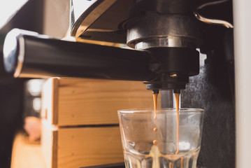Espresso coffee preparation using coffee machine at home, shallow depth of field