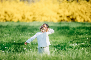 A LITTLE GIRL IN THE FLOWERING SPRING GARDEN
