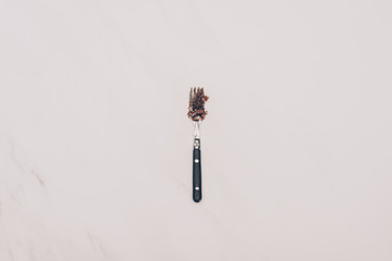 top view of fork with cake pieces isolated on grey