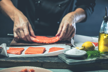 Chef Koch in der Küche (Lachs Fisch gericht)
