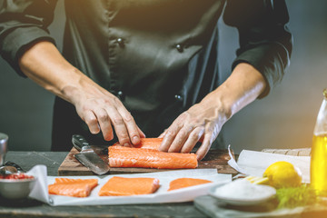 Chef Koch in der Küche (Lachs Fisch gericht)