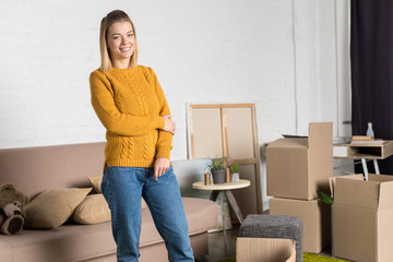 beautiful young woman smiling at camera while moving home