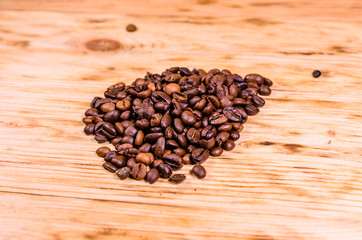 Pile of the roasted coffee beans on wooden table