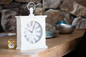 Fototapeta na wymiar Simple yellow alarm clock and vintage wise table clock, big and small with the same function