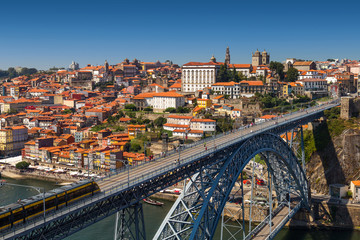 Obraz premium View on old town and historic centre of Porto, Oporto in Portuguese, Portugal as seen from Louis Pont Bridge. Popular touristic destination for port and wine tasting.