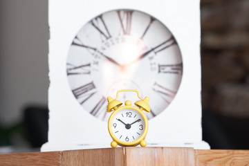 Simple yellow alarm clock and vintage wise table clock, big and small with the same function