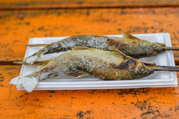 Grilled trout fish on wooden table at Kegon Waterfall, Nikko, Tochigi, Japan.