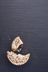 Broken crispbread on stone plate. Dark background. Copyspace for text.