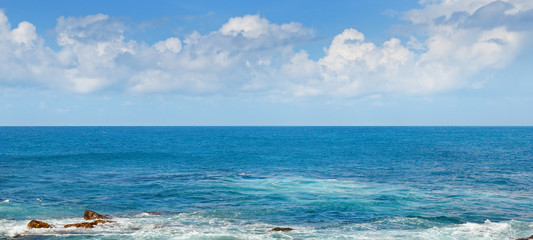 Fototapeta na wymiar Tropical ocean, beach, high waves and blue sky.