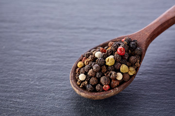 black pepper peas in a spoon on a stone