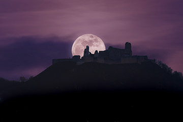 magical moon behind ruins of medieval castle