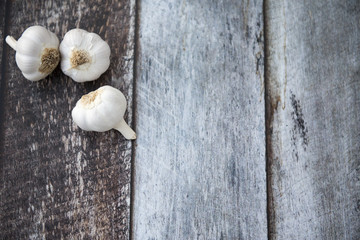 Three cloves of garlic on a wooden background with copy space 