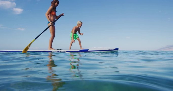 Family stand up paddle boarding having fun in the ocean