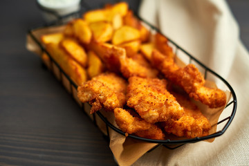 Nuggets and baked potatoes in a beautiful basket with white sauce