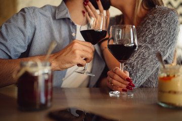 Close-up of glasses filled with red wine. Couple clinking. Anniversary, Valentine's day, romantic concept.