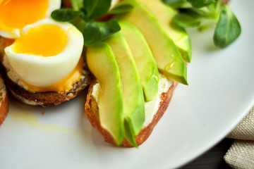 Bruschetta, assorted, different fillings, on plates with a soft-boiled egg in the middle