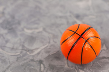 One new orange soft rubber basketball ball on old worn cement