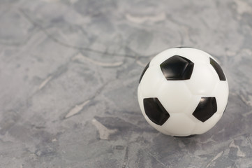 One new black and white soft rubber soccer ball on old worn cement
