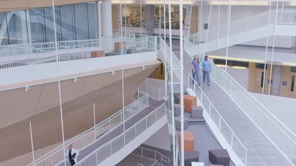 High angle handheld shot of coworkers in hospital corridor