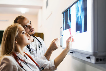 group medical workers man and woman examining x-ray photograph. concept spinal injury, hip, bones...