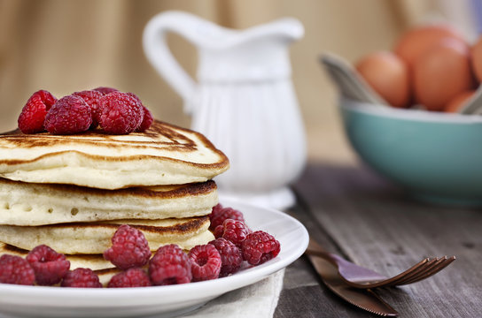 Delicious homemade golden pancakes with fresh raspberries. Extreme shallow depth of field.