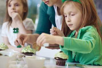Family decorating cupcakes at kitchen