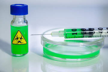 dangerous substance in a syringe, a vial and a petri dish on a table in a chemical laboratory