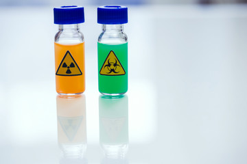 Biologically dangerous substance and radioactive substance in the vials on a table in a chemical laboratory