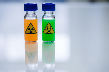 Biologically dangerous substance and radioactive substance in the vials on a table in a chemical laboratory