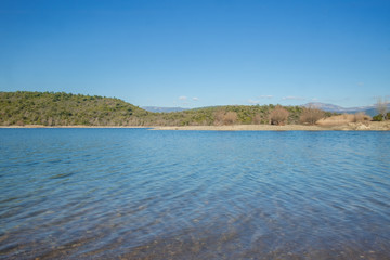 blaues Wasser und blauer Himmel in hügeliger Landschaft