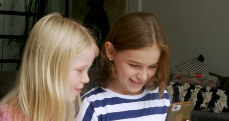 Two beautiful young girls taking selfie photos with a smart phone - Powered by Adobe