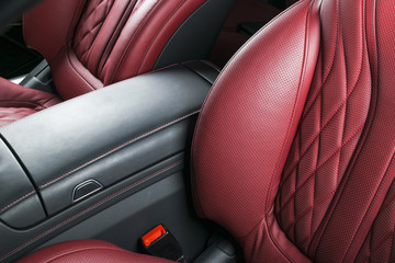 Modern Luxury car inside. Interior of prestige modern car. Comfortable leather red seats. Red perforated leather cockpit. Automatic transmission. Modern car interior details