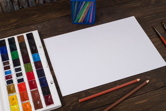 Paints, pencils and brushes on wooden to a floor. Image preprocessing