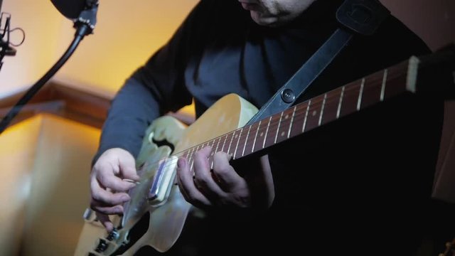 Musician playing jazz music by vintage electric guitar at recording studio close-up