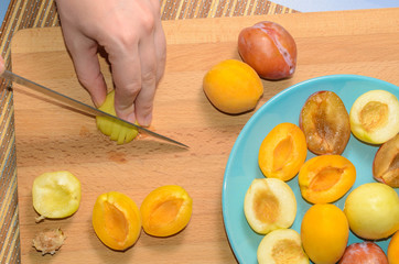 Hand cuts fruit on a wooden board