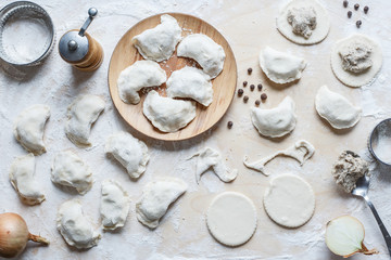 The process of making homemade traditional dumplings on a wooden board.  Cutting and stuffing...