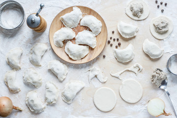 The process of making homemade traditional dumplings on a wooden board.  Cutting and stuffing...