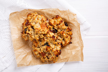 Healthy oatmeal cookies with raisins on white table.