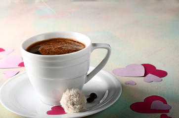 St.Valentines hot coffee with raffaello and paper hearts on light background
